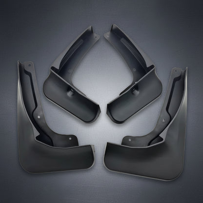Four black plastic vehicle mud flaps arranged symmetrically on a plain white background.
