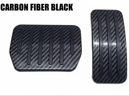 Two black carbon fiber textured pedal covers for a vehicle, shown on a plain white background.