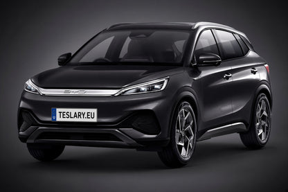 BYD ATTO3 EV ACCESSORIES BUY FROM EUROPES TESLARY.EU A dark metallic gray BYD SUV with a custom license plate reading 'TESLARY.EU', shown from a three-quarter front angle against a dark gray studio background.